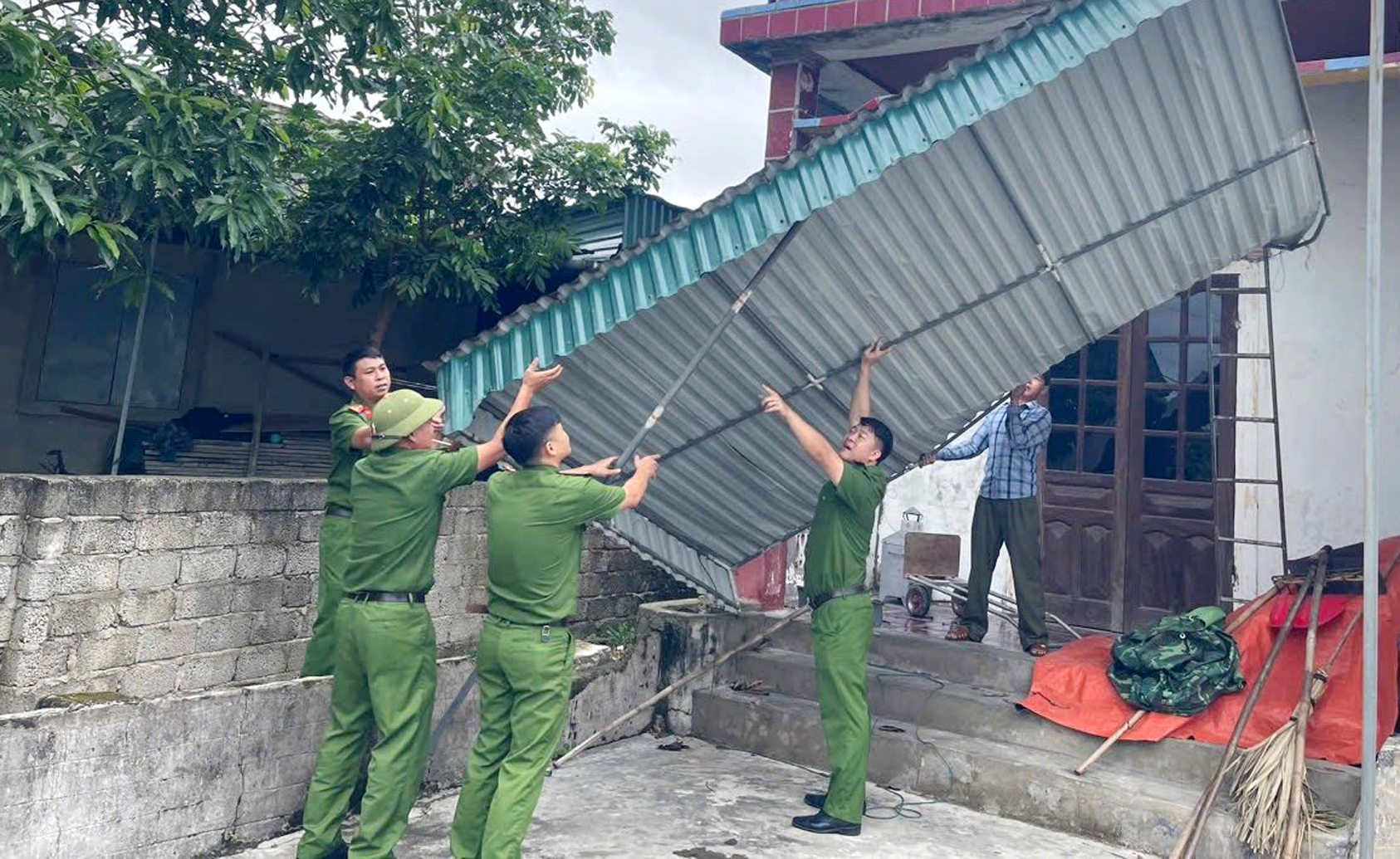 Lực lượng Công an dầm mình giúp dân khắc phục hậu quả giông lốc -0