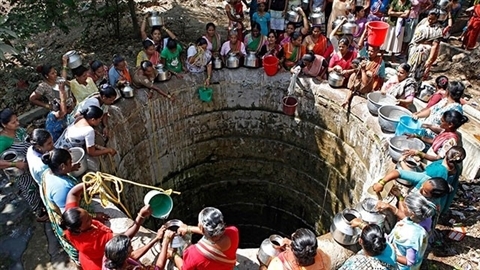 Người dân Ấn Độ đu dây xuống giếng sâu lấy nước về dùng