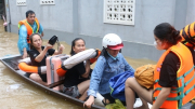 Công an lội nước đẩy thuyền giúp người dân thoát khỏi vùng ngập lụt nguy hiểm