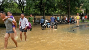 Công an huyện giúp dân di chuyển qua đoạn đường bị ngập do mưa lớn