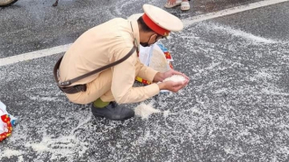 CSGT giúp người dân thu gom gạo rơi vãi trên đường