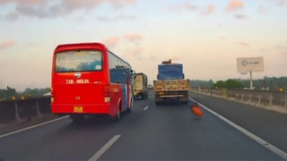 Cuộn bạt trên xe tải rơi xuống đường khiến ô tô khác suýt mất kiểm soát