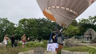 Khinh khí cầu tham gia lễ hội đáp xuống... nghĩa trang