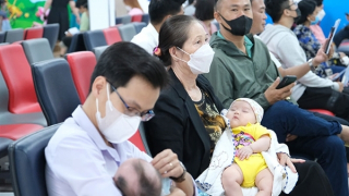 Người dân tranh thủ vừa tiêm chủng, vừa tránh nóng