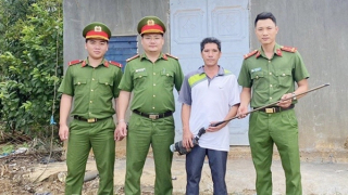 Một chiến sĩ Công an vận động người dân giao nộp nhiều súng tự chế