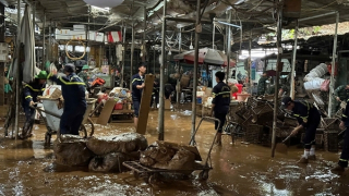 Công an mang cuốc xẻng, xe đẩy dọn dẹp bùn đất sau lũ