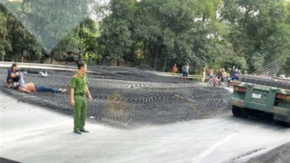 Hàng tấn thép lưới rơi từ xe đầu kéo xuống đường đè 2 người đi xe máy