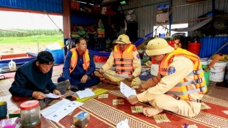 Cảnh sát đường thuỷ cùng cán bộ xã đưa thông tin bầu cử đến với bà con sông nước