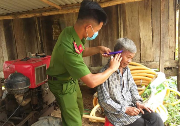 Công an huyện Mang Yang về làng cắt tóc, tuyên truyền pháp luật cho dân -1