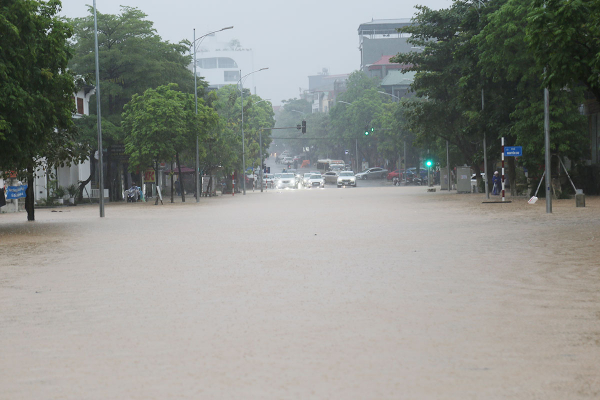 Hỗ trợ người dân đi qua các đoạn đường bị ngập úng sau trận mưa lớn -1