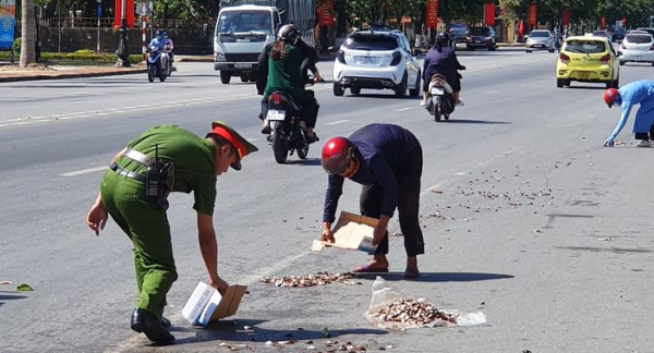 Hình ảnh đẹp chiến sỹ Công an thu gom cá giúp người dân trên đường  -0