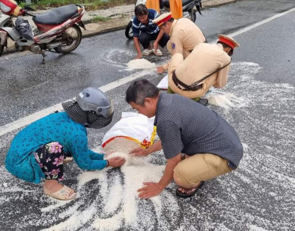 Traffic police help people clean up rice spilled over on the road -0