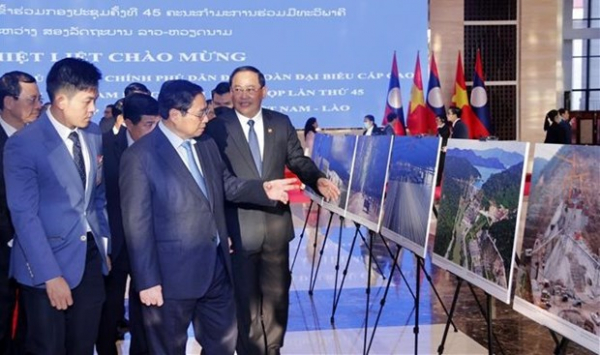PMs of Vietnam, Laos visit photo exhibition on achievements of economic ties -0