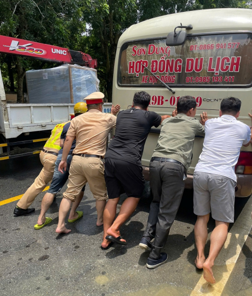 Công an huyện Bảo Thắng giúp dân di chuyển qua đoạn đường bị ngập do mưa lớn -0