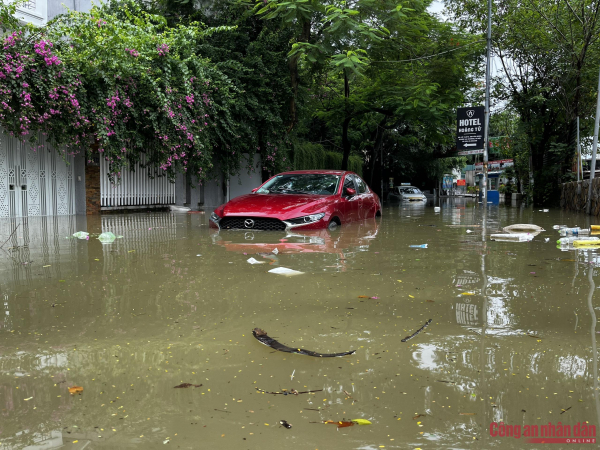 Đường phố Hà Nội vẫn ngập sâu sau mưa lớn, người dân dắt xe máy qua biển nước -1