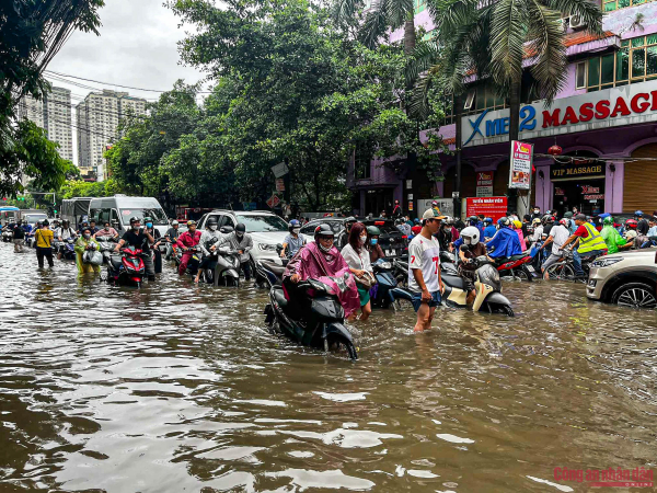 Đường phố Hà Nội vẫn ngập sâu sau mưa lớn, người dân dắt xe máy qua biển nước -2