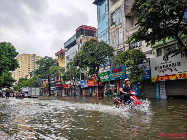 Đường phố Hà Nội vẫn ngập sâu sau mưa lớn, người dân dắt xe máy qua biển nước -3