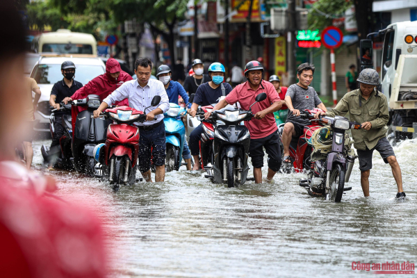 Đường phố Hà Nội vẫn ngập sâu sau mưa lớn, người dân dắt xe máy qua biển nước -5