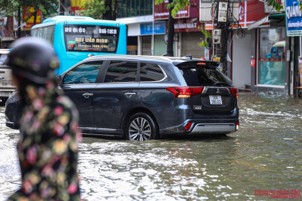 Đường phố Hà Nội vẫn ngập sâu sau mưa lớn, người dân dắt xe máy qua biển nước -8