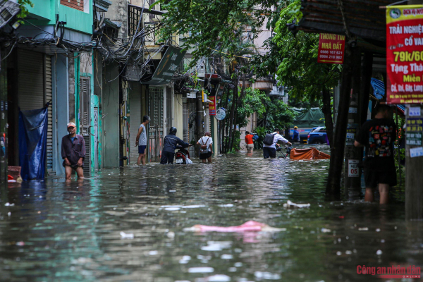 Đường phố Hà Nội vẫn ngập sâu sau mưa lớn, người dân dắt xe máy qua biển nước -9