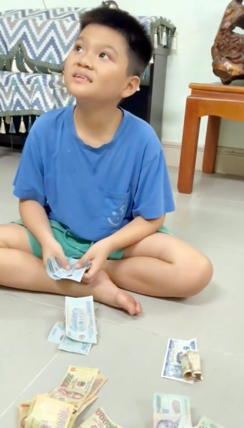 cậu bé lớp 5 đập ống heo góp quỹ ub mttq vn.jpg -0