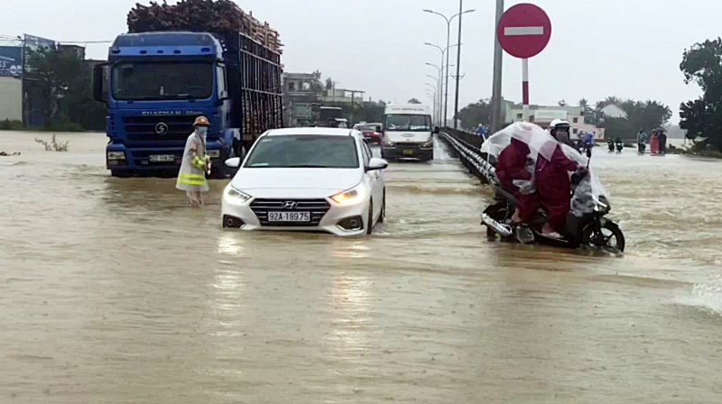 Nước lũ tràn qua QL1A, lực lượng CSGT làm “cọc tiêu sống” hướng dẫn giao thông -0