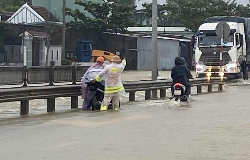 Nước lũ tràn qua QL1A, lực lượng CSGT làm “cọc tiêu sống” hướng dẫn giao thông -0