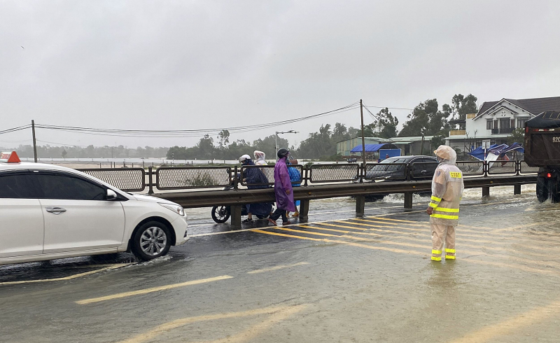 Nước lũ tràn qua QL1A, lực lượng CSGT làm “cọc tiêu sống” hướng dẫn giao thông -0