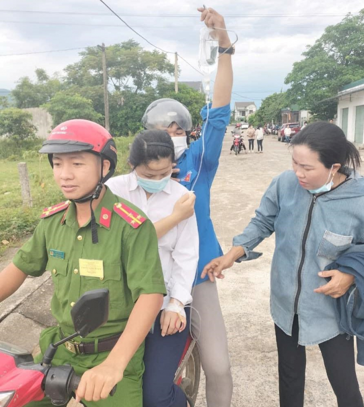 Công an xã hỗ trợ thí sinh đeo bình truyền nước trên tay đến phòng thi -0