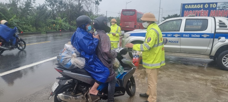 CSGT đội mưa tiếp đồ ăn, thức uống cho người dân trở lại miền Nam làm việc sau Tết -0