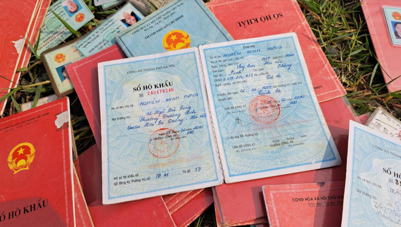 Hàng chục sổ hộ khẩu, CMND, con dấu tròn và Quốc huy Công an trên đường dân sinh -0