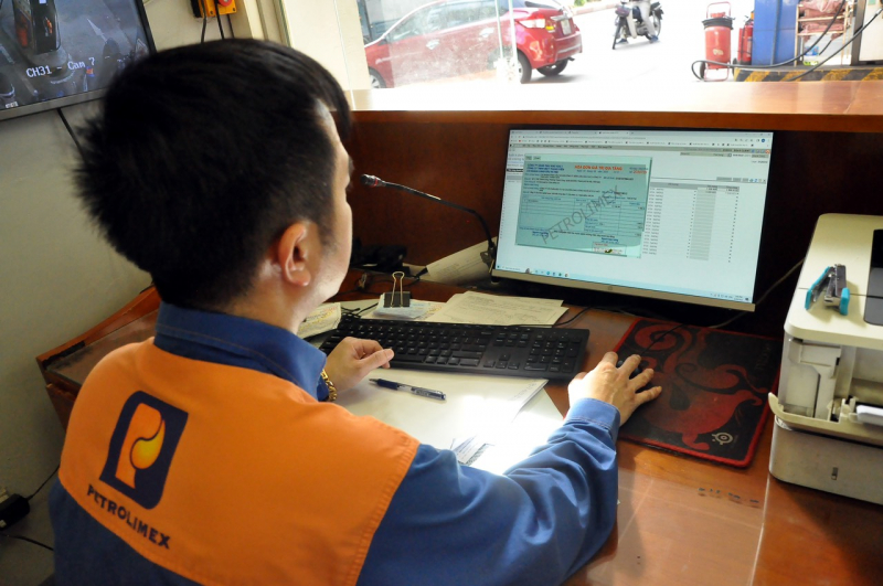 nhân viên xuất hóa đơn ngay cho khách hàng sau khi mua xăng tại petrolimex.jpg -0