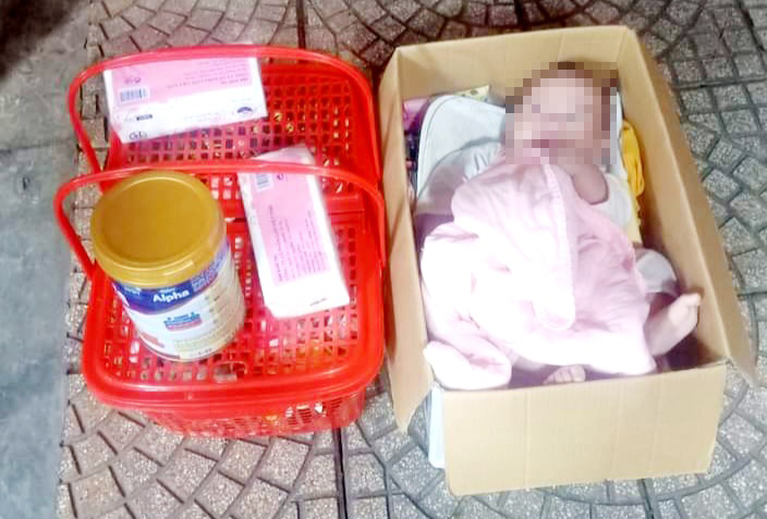 Người nhà đến nhận bé gái bị bỏ rơi trong thùng giấy trước cửa nhà dân  -0
