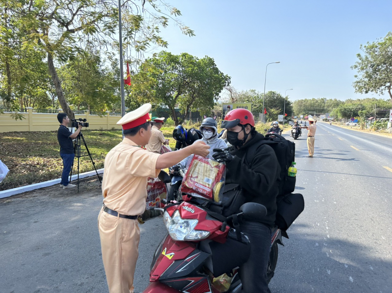 CSGT tặng mũ bảo hiểm, bánh chưng để tiếp sức cho người dân về quê ăn Tết -1