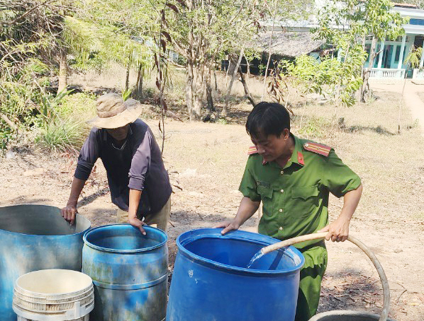 Công an xã đội nắng đưa nước sạch đến với người dân -0