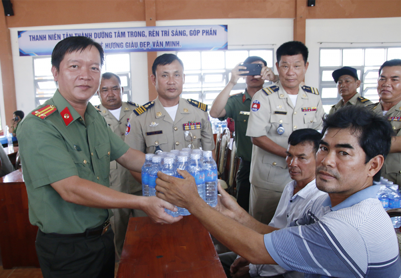 Công an 2 tỉnh Kandal và An Giang trao hỗ trợ nước suối cho người dân vùng hạn, mặn  -0