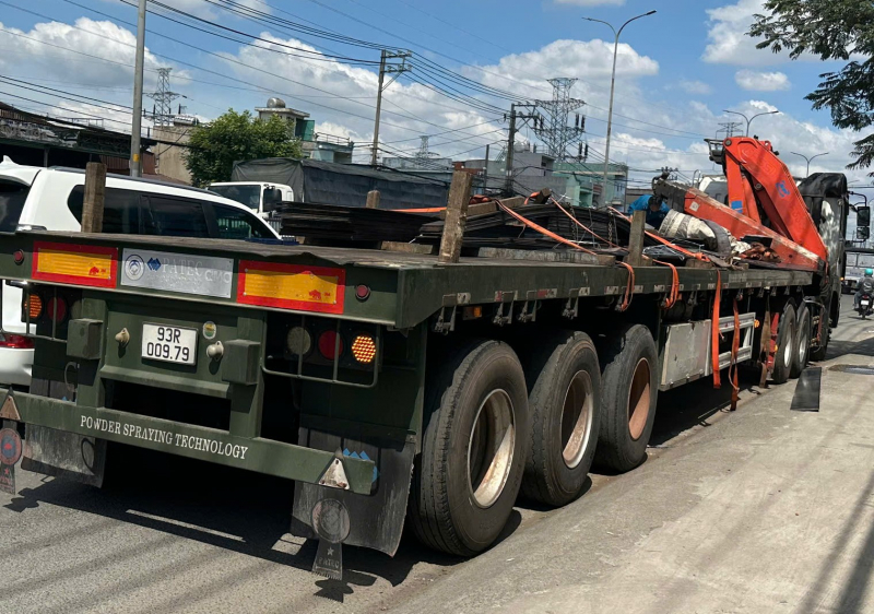 Thắng gấp, hàng chục tấm thép nặng hàng tấn rơi trúng chân người đi đường -0