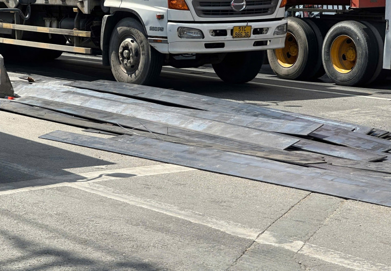 Thắng gấp, hàng chục tấm thép nặng hàng tấn rơi trúng chân người đi đường -0