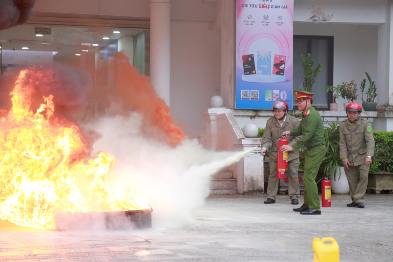 tổ chữa cháy dùng bình chữa cháy xách tay tiếp cận điểm cháy, phun luân phiên để khống chế ngọn lửa.jpg -0