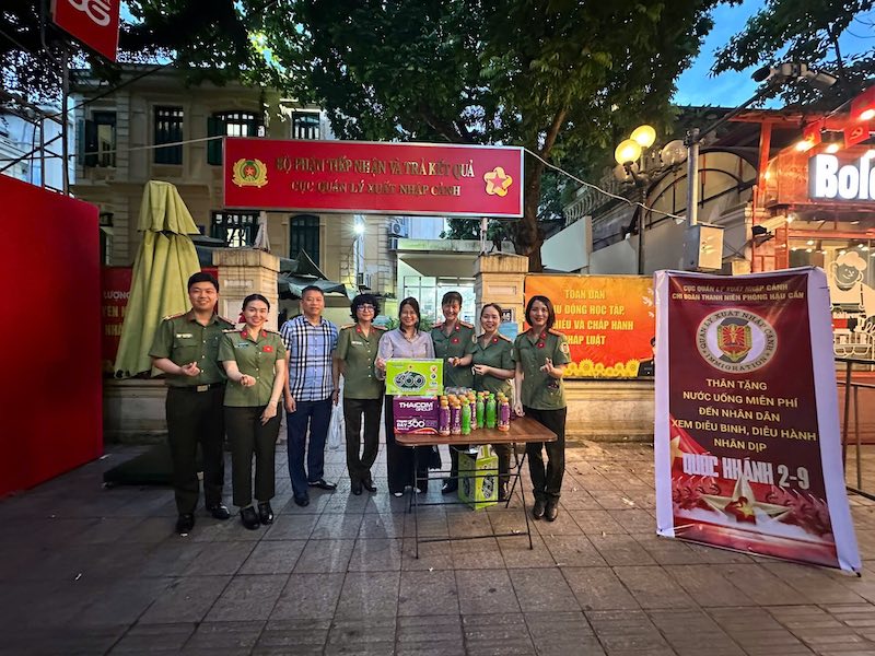 Cán bộ Cục Quản lý xuất nhập cảnh tặng nước phí, hỗ trợ người dân xem diễu binh, diễu hành -0