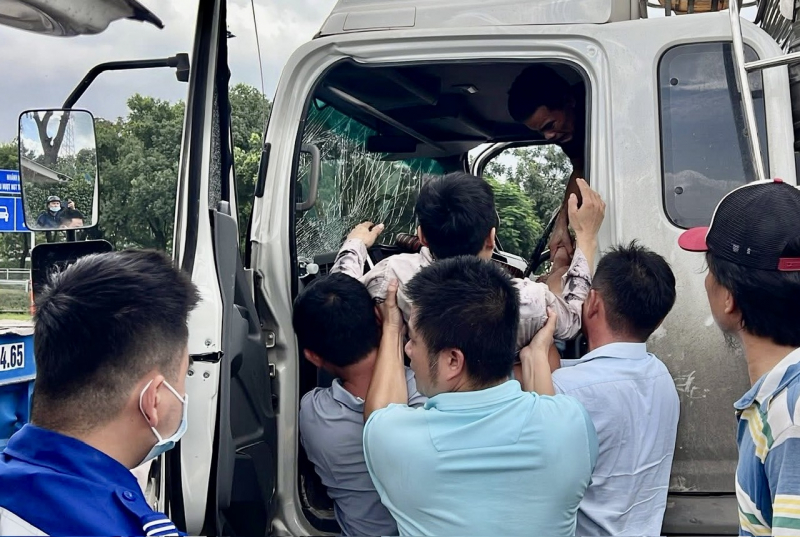 Nhiều người hợp sức phá cabin giải cứu tài xế xe tải sau va chạm với rơ-mooc xe đầu kéo -1