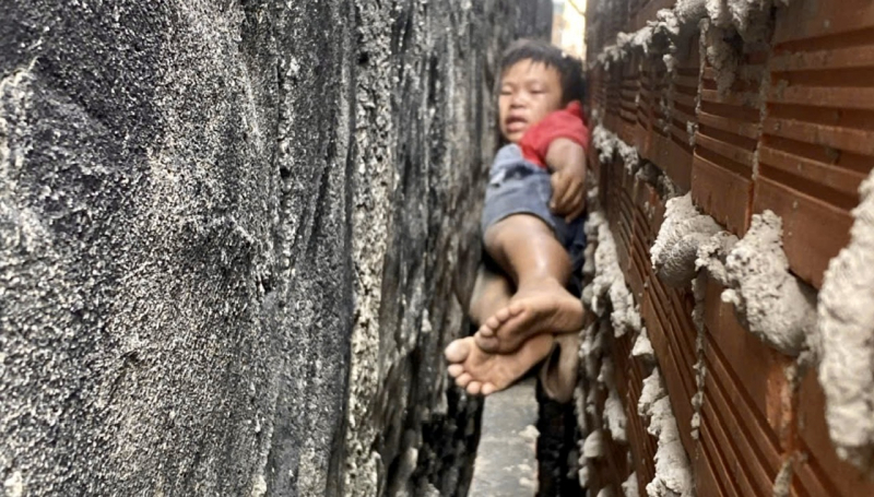 20 phút nghẹt thở giải cứu bé trai mắc kẹt giữa vách 2 căn nhà -0