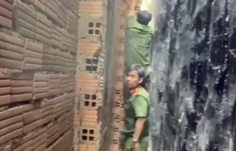 20 phút nghẹt thở giải cứu bé trai mắc kẹt giữa vách 2 căn nhà -0