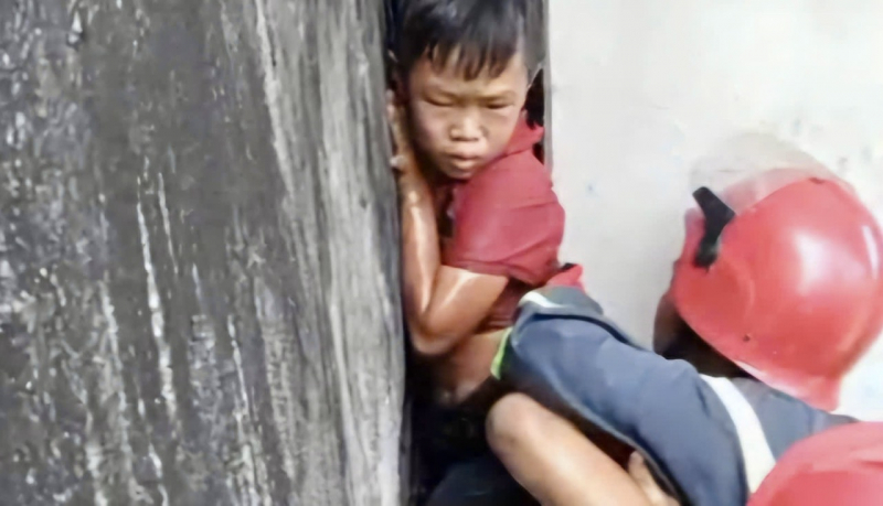 20 phút nghẹt thở giải cứu bé trai mắc kẹt giữa vách 2 căn nhà -1