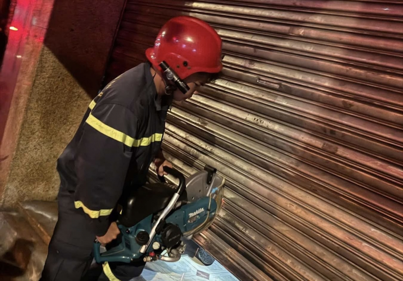 Cắt cửa cuốn giải cứu 2 người thoát sự cố cháy nhà 6 tầng  -1